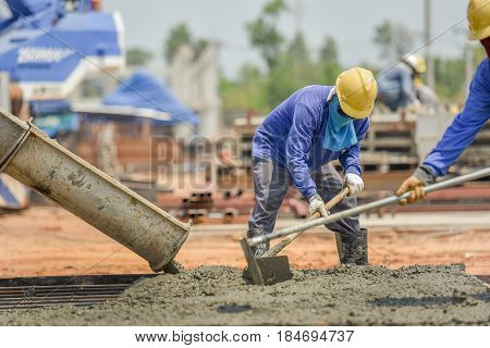 Construction worker Concrete pouring during commercial concreting floors of building in construction site and Civil Engineer or Construction engineer inspec work