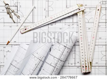 Rolls Of Architectural Blueprint House Building Plans On Blueprint Background With Folding Rule, Pen