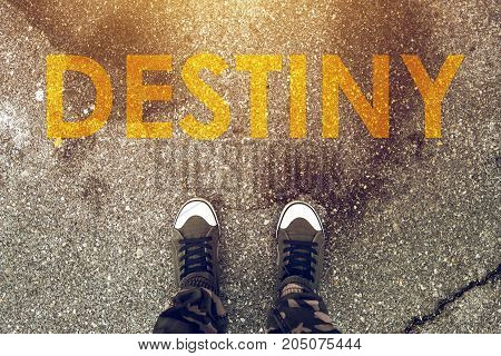 Young person standing on the road with Destiny imprint on pedestrian walkway. Making right choices and deciding about future steps determines your fate.