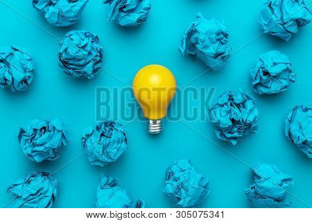 New Idea Concept With Blue Crumpled Office Paper And Light Bulb. Top View Of Business Idea Concept O