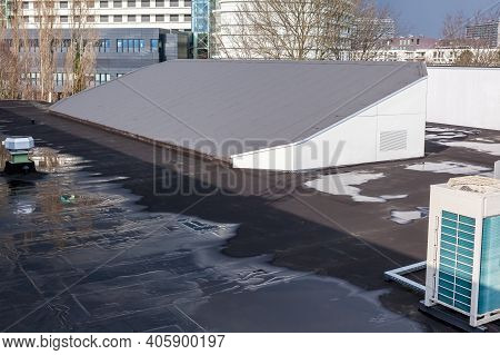 On A Large Gym Building There Is A Sloping Roof With Roofing