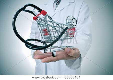 doctor holding in his hand a shopping cart with a stethoscope inside, depicting the health care industry concept