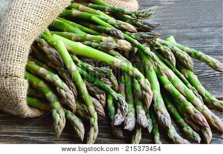 Asparagus or garden asparagus in sack bag on wooden floor