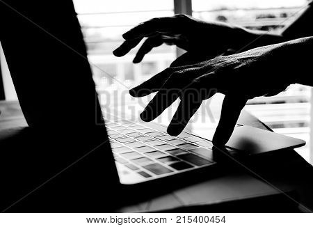 Cyber crime hand reaching out through laptop computer and attack signifying in internet theft while using online banking Payment Security Concept. Anonymous Hacked in Black