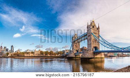 Panoramic London skyline with iconic symbol, the Tower Bridge and Her Majesty's Royal Palace and Fortress, known as the Tower of London as viewed from South Bank of River Thames in the morning light