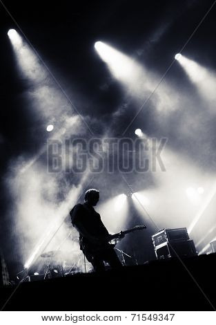 Rock concert stage. Guitarist playing on electric guitar.