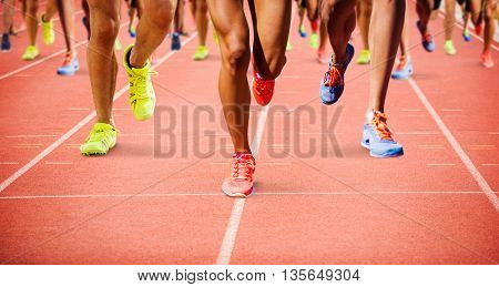 Close up of sportsman legs running against focus of athletics track