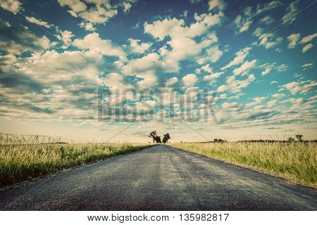 Empty straight long asphalt road. Dramatic cloudy sky. Concepts of travel, adventure, destination, transport etc. Vintage style