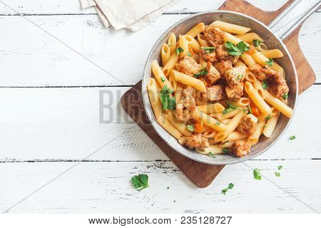 Penne Pasta In Tomato Sauce With Chicken,  Parsley In Pan. Chicken Italian Penne Pasta Over White Ba