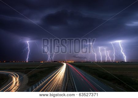 Thunderstorm And Lightnings In Night Over A Highway With Car Lightning