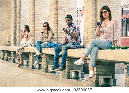 Group Of Young Multiracial Friends Using Smartphone With Mutual Disinterest Towards Each Other