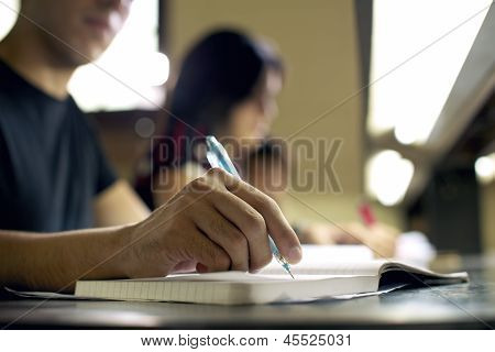 Jonge Man doet huiswerk en studeren In College Library