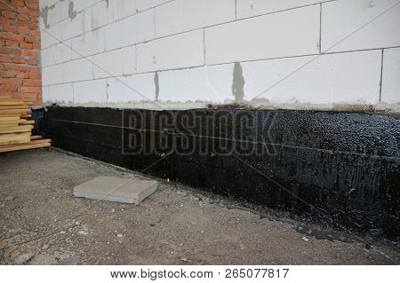 Foundation Bitumen Waterproofing. Building House Construction With Waterproofing Spray-on Tar. Const