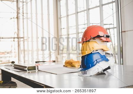 Yellow,white, Blue, Orange Helmet Safety Engineer For Project Engineering.conceptual Images Of Const