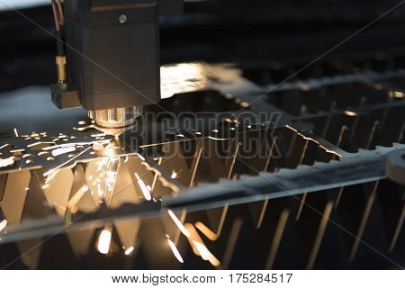 The CNC laser cut machine while cutting the sheet metal with the sparking light.The hi-precision sheet cutting process by laser cut