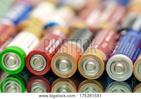 Closeup of pile of used alkaline batteries. Rows of selection of AA batteries energy abstract battery background. Alkaline battery aa size. Storage batteries in rows. Dead battery. Disposal battery. Waste battery. Battery energy. Battery recycling.