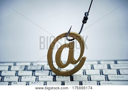 A fish hook with email sign on computer keyboard / Email phishing attack concept