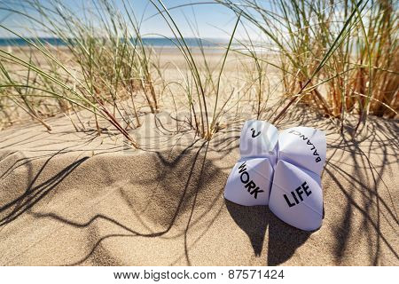 Origami fortune teller on vacation at the beach concept for work life balance choices