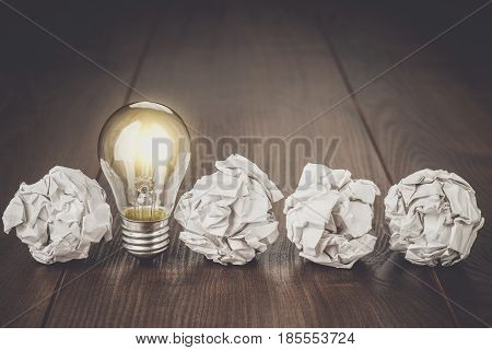 Great idea business concept. Business idea brainstorming concept with crumpled office paper. Great idea as light bulb standing on the office table. Business meeting concept. Business plan idea brainstorming concept.