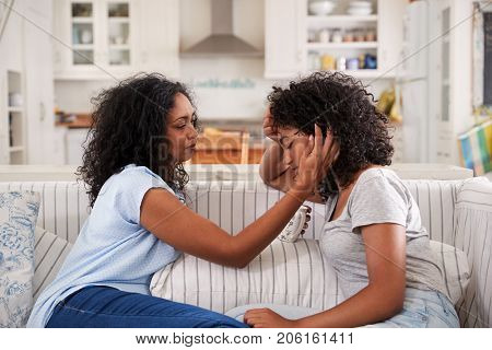 Mother Talking With Unhappy Teenage Daughter On Sofa