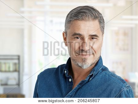 Older man portrait. Gray haired mid adult older man in his 50s wearing casual, smiling.