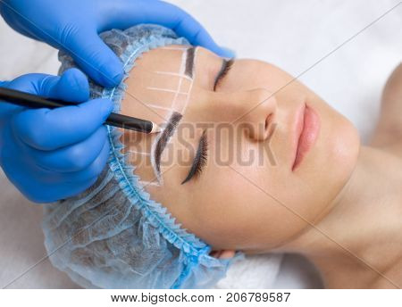 Permanent Make-up For Eyebrows Of Beautiful Woman With Thick Brows In Beauty Salon. Closeup Beautici