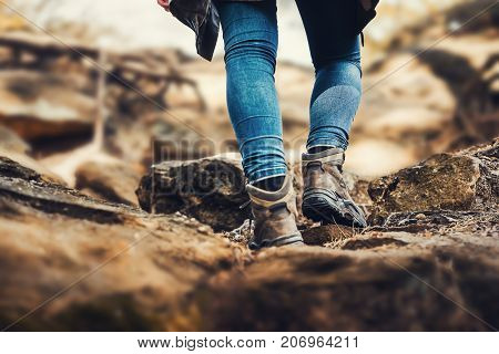 Person is hiking a hill - hiking shoes from behind on a hiking trail