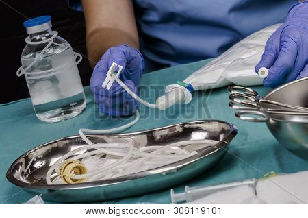 Nurse Shaking Enteral Nutrition Bottle In A Hospital, Palliative Care, Conceptual Image