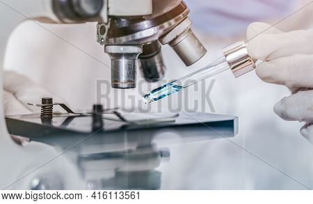 Scientist With Equipment And Science Experiments Laboratory Glassware Containing Chemical Liquid. He