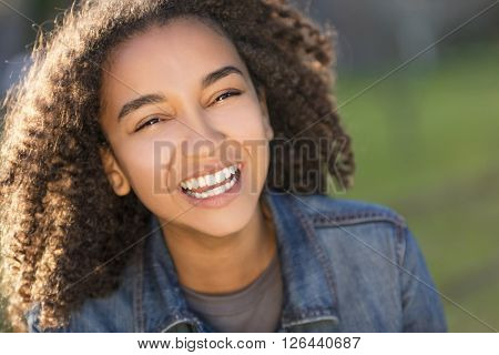 Outdoor portrait of beautiful happy mixed race African American girl teenager female young woman smiling laughing with perfect teeth