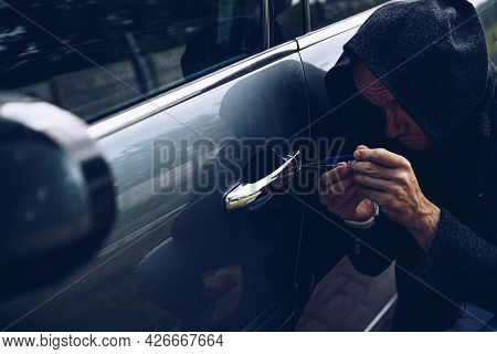 Thief Breaking Into Car With Picklock Or Screwdriver.