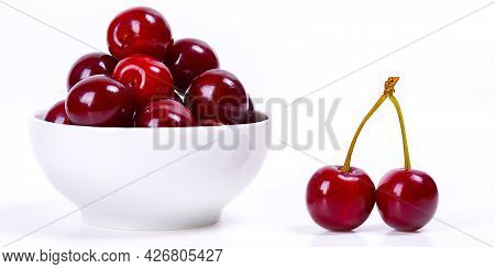 Cherry Berries In A White Cup On A White Background. Isolated. Ripe Cherries. Red Delicious Cherry.