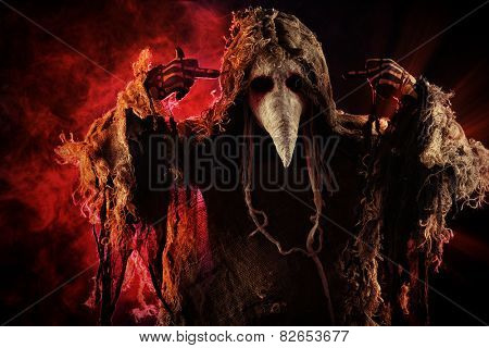 Portrait of a terrible plague doctor with a scythe. Medieval Europe. Horror. Halloween.