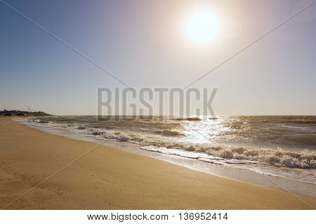 Turquoise sea wave foam on beach. Beautiful water nature. Perfect summer resort for relax. Sea waves near beach. Beautiful sea beach. Summertime, blue sea and waves, yellow sun and sand.