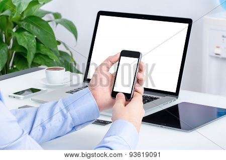 Male Hands Using Smartphone Mockup At The Office Desk With An Open Laptop Mockup