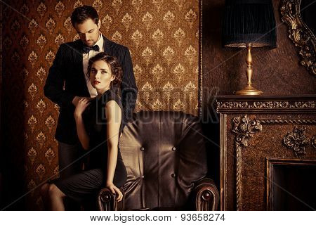 Beautiful man and woman in elegant evening clothes in classic vintage apartments. Glamour, fashion. Love concept.