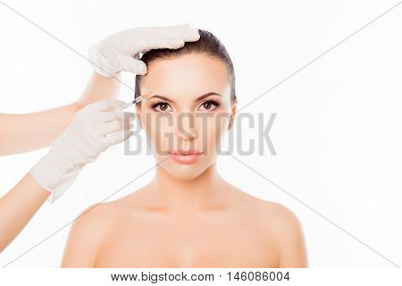 Plastic Surgeon Making Botox Injection In Woman's Eyebrow