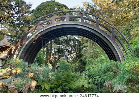 Ponte di legno curvato a giardino giapponese