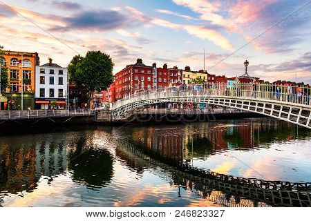 Dublin, Ireland. Night View Of Famous Illuminated Ha Penny Bridge In Dublin, Ireland At Sunset