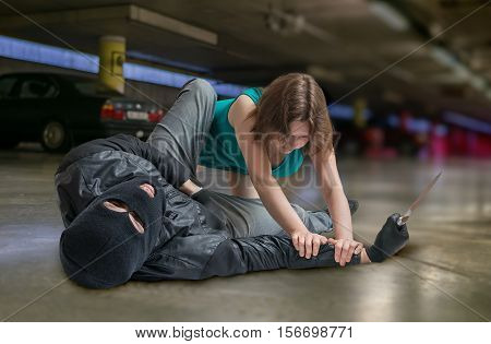 Self defense concept. Young woman is fighting with mugger or thief.