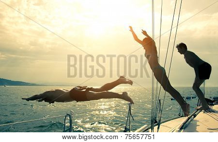 Friends Jumping Into Water From A Sailing Boat