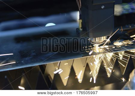 The CNC laser cut machine while cutting the sheet metal with the sparking light.The hi-precision sheet cutting process by laser cut