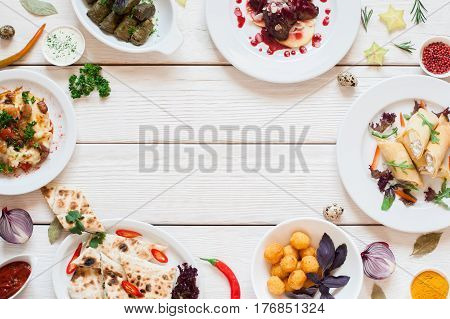 Frame of delicious snacks on white table flat lay. Top view on assortment of tasty breakfast meals, free space on white wooden background. Buffet, restaurant menu, banquet concept