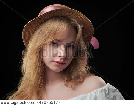 Portrait Of A Beautiful Girl With Blue Eyes On A Black Background In The Studio