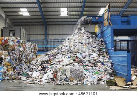 Waste falling on pile from conveyor belt at recycling factory