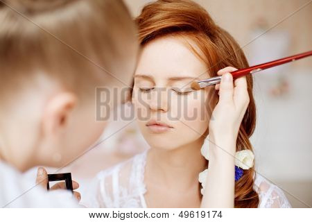 Stylist makes makeup bride on the wedding day