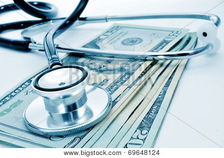 a stethoscope on a pile of US dollar bills, depicting the health care industry concept