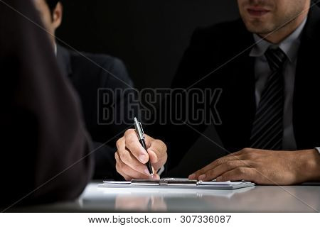 Interrogator Taking Note While Interviewing Suspect In The Interrogation Room