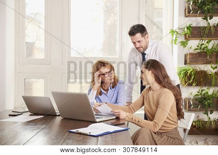 Teamwork In The Office. Group Of Business People Working Together On Laptop In The Office