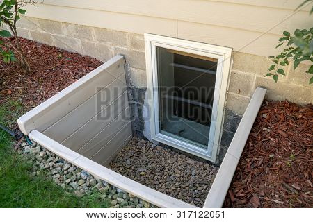 Exterior View Of An Egress Window In A Basement Bedroom. These Windows Are Required As Part Of The U